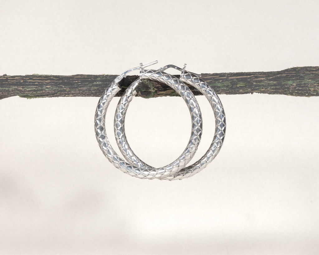Close-up of sterling silver diamond-cut hoop earrings