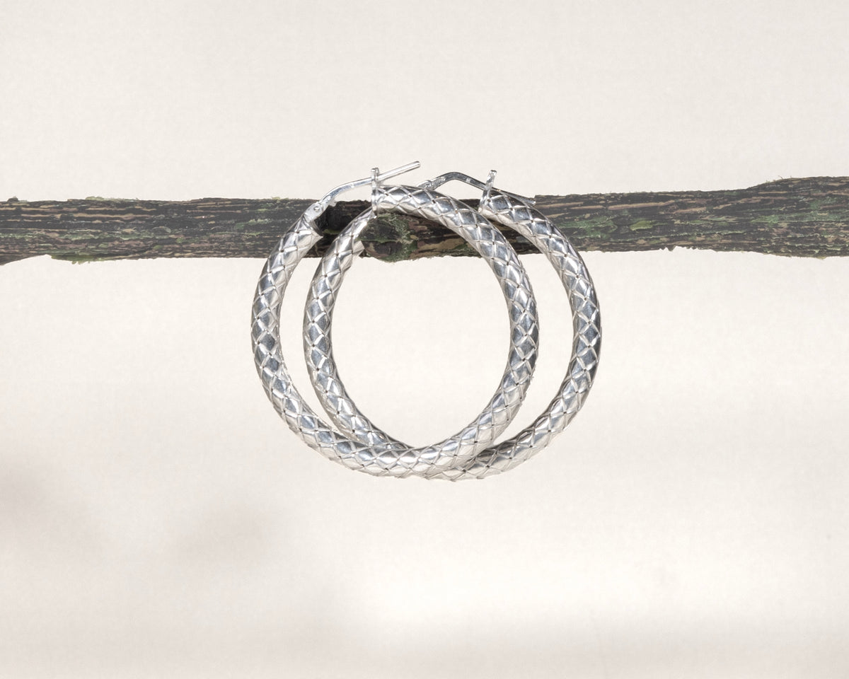 Close-up of sterling silver diamond-cut hoop earrings